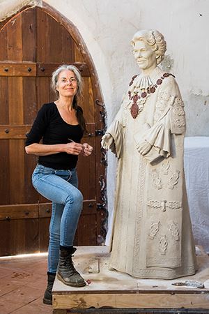 Sculptor Margot Stephens with her as-yet unfinished statue of Joy Cummings.
