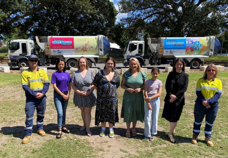 City of Newcastle waste collection truck driver Peter Hayward, Go Circular CEO Annie Jiang, Our Lady of Victories, Shortland teacher Lisa York, high school category winner Betsy Smith, Newcastle Lord Mayor Nuatali Nelmes, primary school category winner Sofia Puerto, Newcastle Art Gallery Head of Curatorial & Exhibitions Miriam Kelly and City of Newcastle waste collection truck driver Rene Griffin in front of the winning artworks on the waste collection trucks.