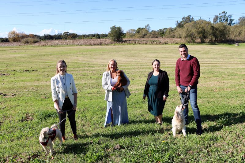 Cr Elizabeth Adamczyk, Lord Mayor Nuatali Nelmes, Cr Deahnna Richardson and Deputy Lord Mayor Declan Clausen with Moby, Ginger and Toby at the Maryland Reserve site where stage one of the new fenced off-leash dog park is being built.