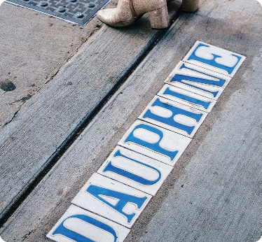 Tiled letters on a footpath that say “Dauphine”.