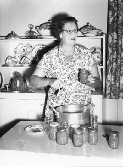 Florence Austral in a kitchen with canned preserves