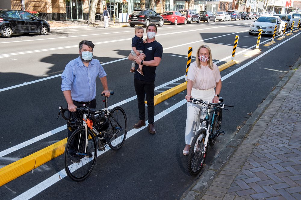 Councillor John Mackenzie, Papa's Bagel Bar's Johno Quinn with son Elijah, and Lord Mayor Nuatali Nelmes on Hunter Street at the location of the new Hunter Street Trial Cycleway.